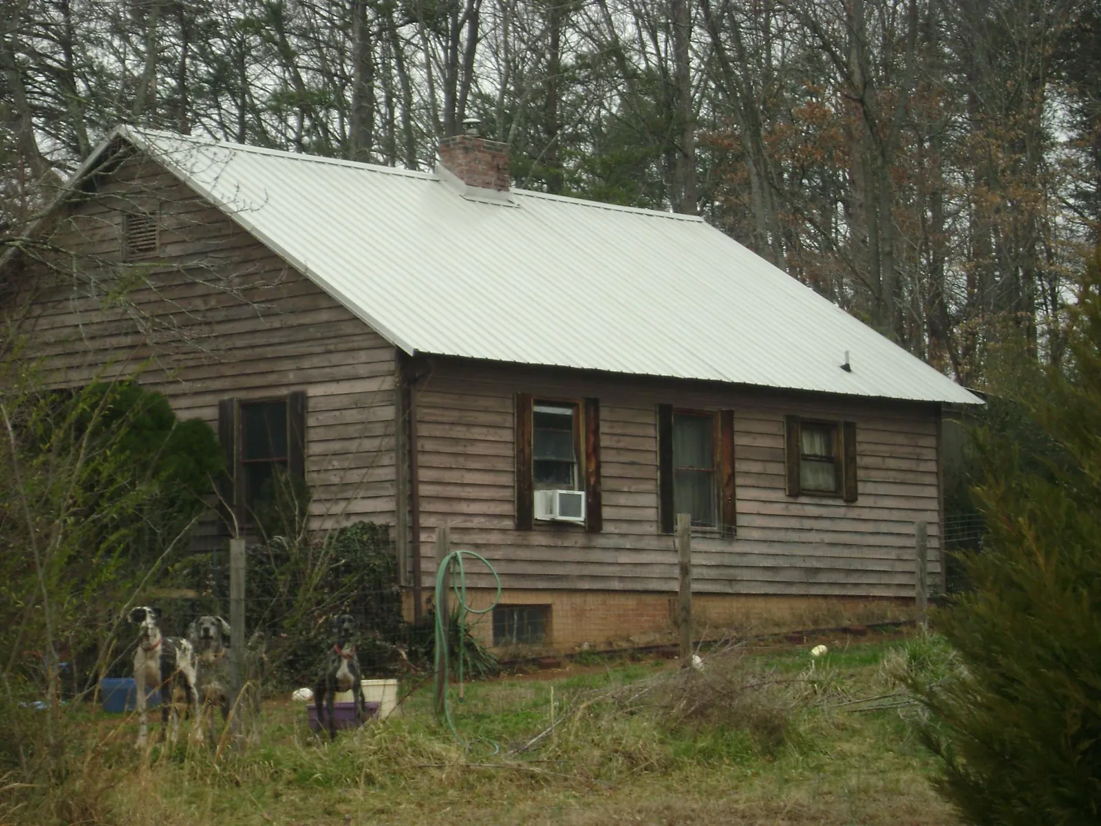 White metal roof on an old wood sided farmhouse, from a Metal Roof Installation job in Louisburg